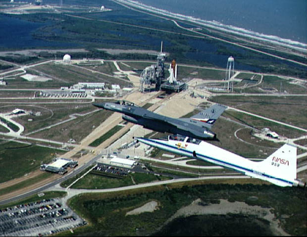 Image of an F-16 and T-38 with STS-108 in background.